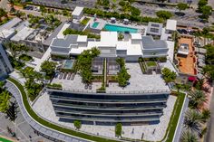 an aerial view of a large building with lots of greenery on the roof and sides