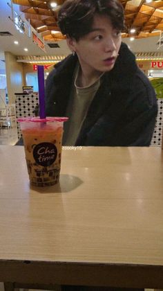 a man sitting at a table with a drink in front of him