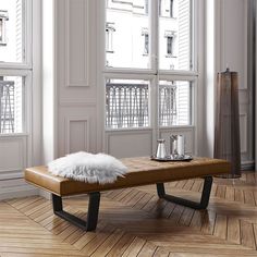 a bench with a fur on it in front of two windows and wooden flooring