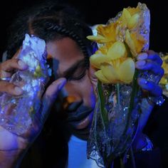 a man holding flowers in front of his face