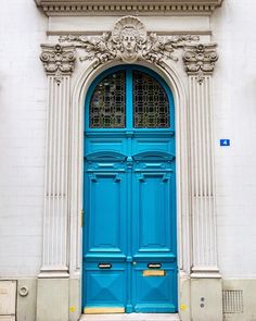 a large blue door on the side of a white building