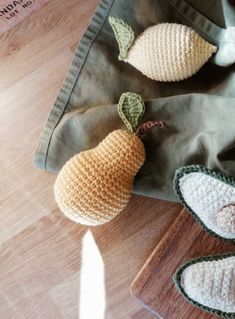 two crocheted pears are sitting on a bag