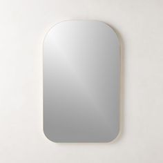 a white wall with a mirror hanging on it's side next to the wall