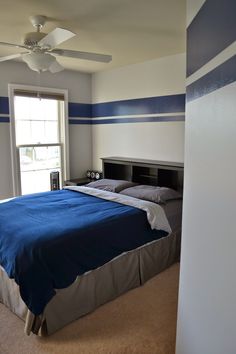 a bedroom with blue and white striped walls