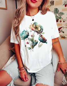 Keywords: Watercolor Flower Tee, Summer Shirt, Flower Lover Shirt, Nature lover Shirt, Floral Shirt, Ladies Top, Best friend gift, Wildflower tshirt. Introducing our latest floral masterpiece - the Watercolor Flower Shirt. This stunning design is sure to turn heads with its beautiful flowers in a soft and delicate watercolor style. Crafted from premium quality materials, this shirt is both lightweight and comfortable, making it perfect for any occasion. The breathable fabric ensures maximum comfort, while the flattering cut and stylish design make it a versatile addition to any wardrobe. Indulge in the utmost comfort and style with our BlendedApprl Unisex T-shirts. Crafted with premium quality, these tees are incredibly soft and cozy to wear. They are made from a blend of 100% cotton for s White Watercolor Print Short Sleeve Top, White Watercolor Print Short Sleeve T-shirt, White Relaxed Fit T-shirt With Watercolor Print, Casual White T-shirt With Watercolor Print, Casual White Tops With Watercolor Print, Multicolor Summer Shirt As Gift, Multicolor Summer Shirt As A Gift, Cute Short Sleeve T-shirt With Plant Print, Casual White Top With Watercolor Print