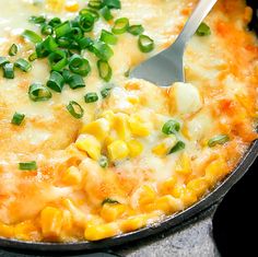 a skillet filled with corn and green onions