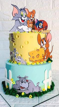 a three tiered cake with cartoon characters on it