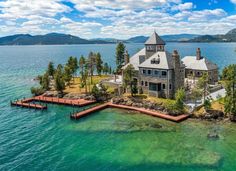 an aerial view of a house on the water with a dock in front of it