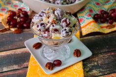 a bowl filled with fruit and nuts on top of a white plate next to a yellow napkin