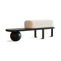 a black bench with a white blanket on it and a wooden ball sitting next to it