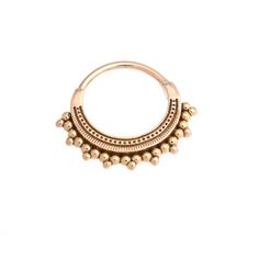 a gold nose ring with beaded details on the outside and an open hole in the middle