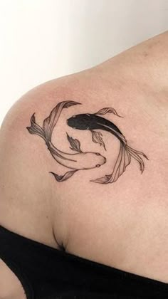 a woman with a tattoo on her shoulder has a goldfish in it's stomach