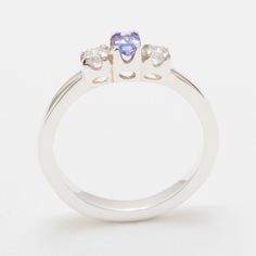 "A Wonderfully simple trilogy ring with a super thick shank. One Tanzanite & two Cubic Zirconia all held securely in place with 4 claws each, the Tanzanite measures 5x3mm oval (0.2\"x0.12\") and the Cubic Zirconia are approx 2.75mm (0.11\"). The vibrant color of the Tanzanite compliments wonderfully the clear sparkling Cubic Zirconia The ring has been Designed & Made in England by traditional family Jewelers. On the inside of the shank there is a Full British Hallmark which includes 750 (the pur Trilogy Ring, Tanzanite Diamond, Natural Tanzanite, Yellow Rose, Pink Tourmaline, Diamond White, Birmingham, Blue Topaz, Amazing Art