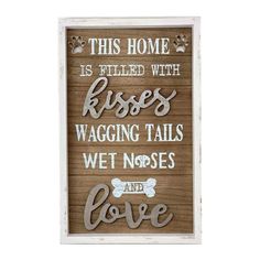 a wooden sign that says this home is filled with kisses, wagging tails, wet noses and love