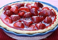 a bowl filled with strawberries on top of a table