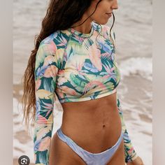 Billabong Rides And Tides Long Sleeve Cropped Rashguard For Women Green Multicolor Tops For Surfing, Beach Season, Multicolor Tops For Surfing Beach Season, Tropical Long Sleeve Swimwear For Beach Party, Tropical Fitted Top For Beach Party, Fitted Tropical Top For Beach Party, Long Sleeve Tropical Print Swimwear, Long Sleeve Tropical Print Beachwear, Summer Long Sleeve Swimwear With Tropical Print, Fitted Beachy Top For Beach Party