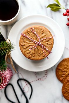 a cookie on a plate next to a cup of coffee and some candy canes