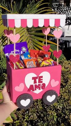 a pink cart filled with candy and candies on top of a lush green field