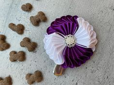 a purple and white flower sitting on top of a floor next to dry dog food