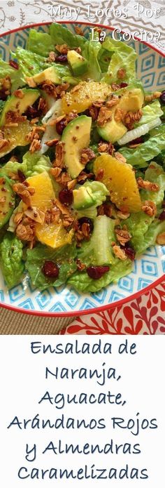 a salad with lettuce, oranges and nuts in it on a plate