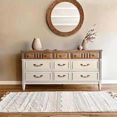 a white dresser sitting in front of a mirror on top of a wooden floor next to a rug