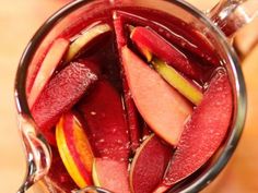 sliced apples and oranges in a glass container with water on the side, ready to be eaten