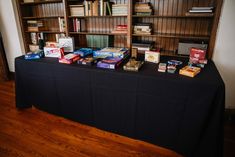 the table is covered with many books and games on it's black cloths