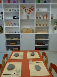 the table is set with place settings for two people to sit at, and there are several shelves behind it