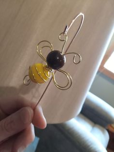 a person holding a piece of wire with a bee on it