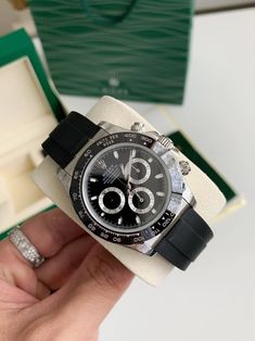 Die Rolex auf dem Bild ist eine Rolex Cosmograph Daytona.  Dieses Modell ist insbesondere am schwarzen Zifferblatt mit silbernen Hilfszifferblättern, der schwarzen Keramiklünette und dem Oysterflex-Armband zu erkennen, die bei einigen modernen Daytona-Referenzen wichtige Designelemente darstellen.
Aufgrund dieser Merkmale ist diese Rolex höchstwahrscheinlich aus der Oyster Perpetual Cosmograph Daytona 116519LN-Serie.  Die Referenznummer für dieses spezielle Modell wäre 116519LN, mit einer schwarzen Keramiklünette und einem schwarzen Zifferblatt mit einem Oysterflex-Armband. Luxury Black Chronograph Watch With Tachymeter, Classic Black Chronograph Watch With Tachymeter, Luxury Black Watch Accessories With Analog Display, Luxury Black Chronometer Watch Accessories, Rolex Cosmograph Daytona, Cosmograph Daytona, Oyster Perpetual, Estonia, Design Element