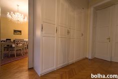 an empty room with white closets and chandelier