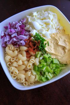 a bowl filled with pasta and vegetables on top of a table