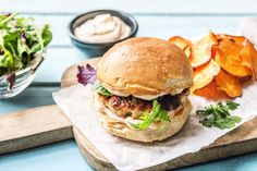 a sandwich and some potato chips on a cutting board