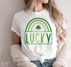 a woman wearing a happy co lucky t - shirt while holding her hands in her pockets