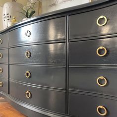 a large black dresser with gold handles and knobs on it's drawers in a living room