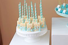 a cake with marshmallows and candy sticks in it sitting on a table