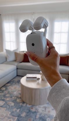 a woman holding up a camera in her living room