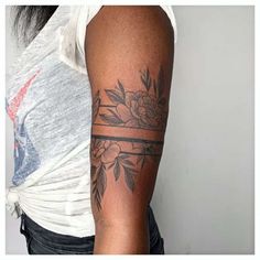 a woman's arm with a flower tattoo on it and a cross in the middle