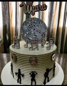 a birthday cake decorated with musical notes and a disco ball on top that says wyro