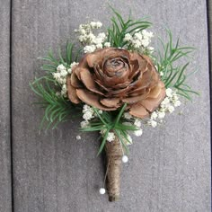 a boutonniere with pine cones and baby's breath is on the ground