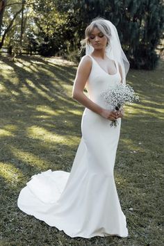 a woman in a wedding dress holding a bouquet