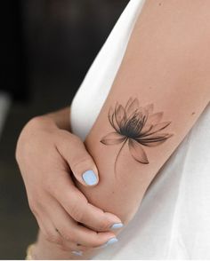 a woman's arm with a flower tattoo on the left side of her arm