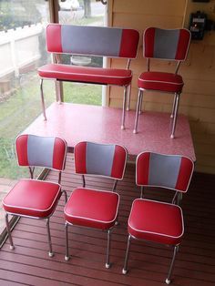 six red and gray chairs sitting on top of a wooden floor next to a window