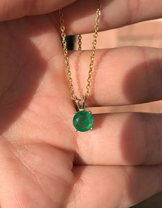 Featured here is a stunning, round natural emerald pendant in fine 14k yellow gold. Displayed in the center is a dark-green emerald accented by a simple four-prong gold mount, allowing for the emerald to be shown in full view. The earth mined, green Colombian emerald has a desirable lush green color. This emerald is 100% earth mined and is not perfect! Gorgeous minor flaws are present within the stone, embrace uniqueness! Chain not included with emerald pendant. Total Carat Weight: 0.90cts Setti Classic Emerald Necklace As Gift, Yellow Gold Solitaire Jewelry For May Birthstone, Classic Emerald Necklace For Gifts, Classic Emerald Necklace With Prong Setting As Gift, Classic 14k Gold Emerald Necklace For May Birthstone, May Birthstone Emerald Necklace In Yellow Gold, Yellow Gold Emerald Necklace With Prong Setting, Classic Yellow Gold Emerald Necklace For May Birthstone, Anniversary Emerald Necklace In Yellow Gold