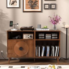 an entertainment center with books, speakers and pictures on the wall