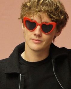 a young man wearing heart shaped sunglasses