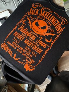 an orange and black jack skellingon's shirt hanging from a hook on a table