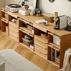 a living room with a large wooden entertainment center next to a wall mounted clock and pictures on the wall