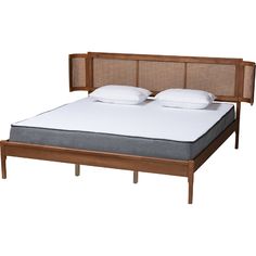 the bed frame has two pillows on it and is made from wood with wicker headboard