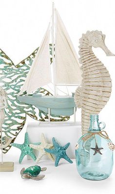 seahorse, starfish and shells in glass vases with sailboat on white background